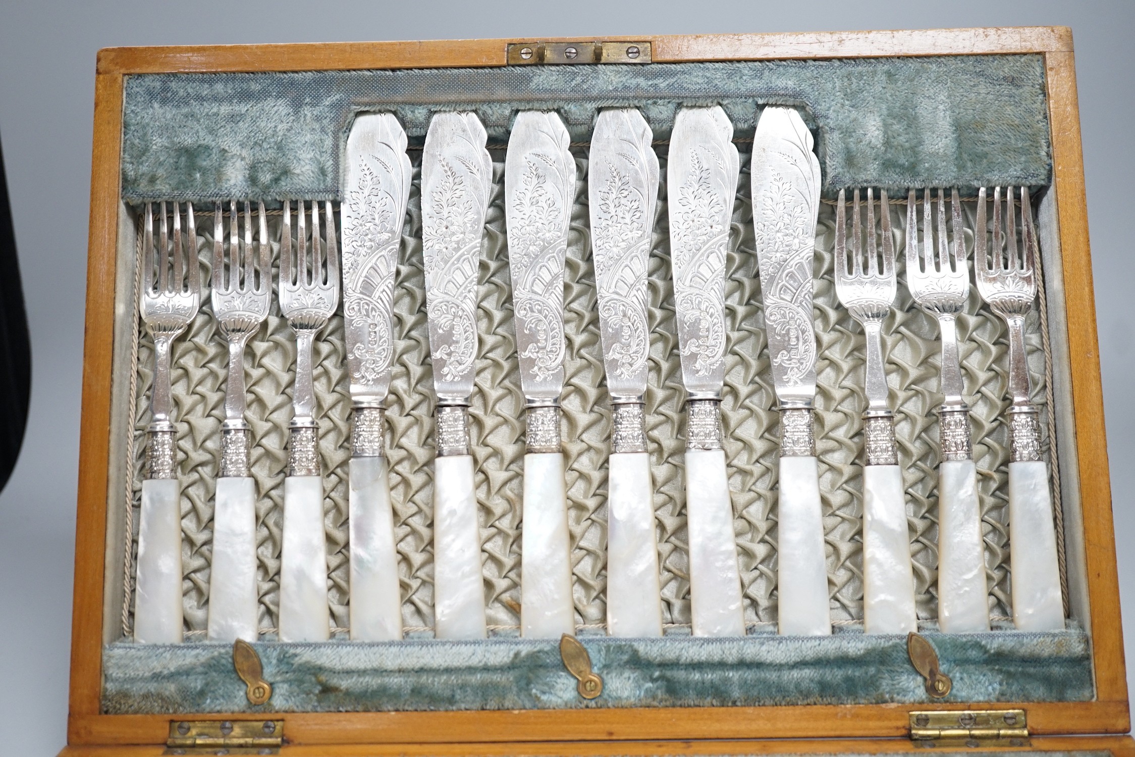A cased set of twelve pairs of Victorian mother of pearl handed silver fish eaters (fork missing) R.F. Mosley & Co, Sheffield, 1894/1895 and a later cased set of twelve pairs of silver handled dessert eaters.